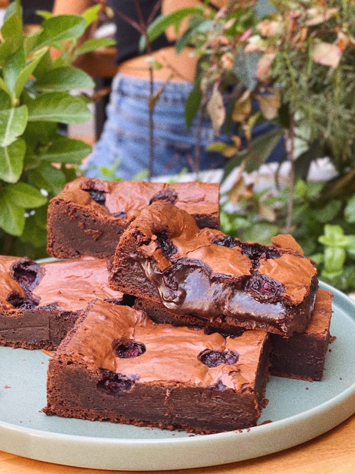 Rich chocolate brownies topped with juicy cherries, perfect for dessert lovers.