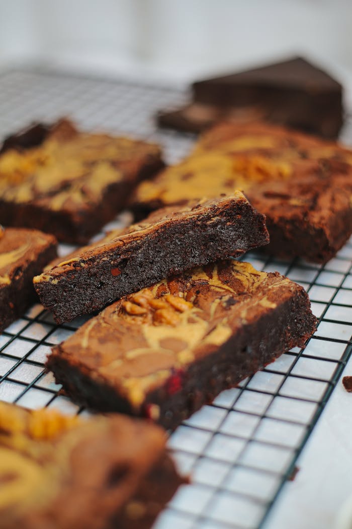 Close-up of homemade fudge brownies with swirled topping on a wire rack.