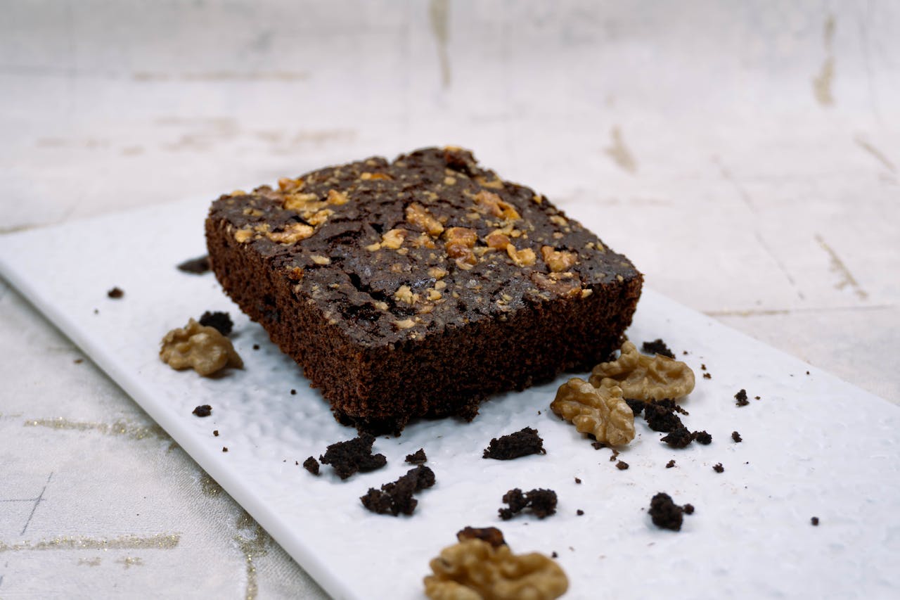 about-us-01 A rich chocolate brownie topped with walnuts, perfect for dessert lovers.