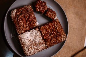 Services Close-up of freshly baked chocolate brownies served on a plate, perfect for dessert lovers.