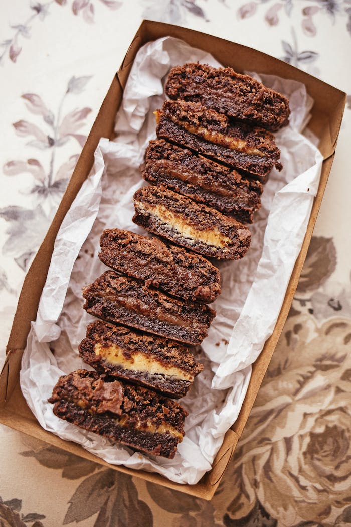 Sliced chocolate brownies arranged neatly in a decorative box, showcasing a tempting dessert presentation.